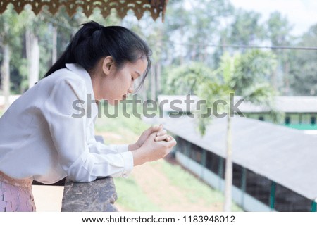 The woman is praying to God.