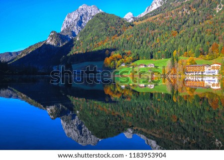 autumn sunny day on Hintersee lake. Beautiful scene of mirror reflection in water of Hintersee lake. Location: resort Ramsau, National park Berchtesgadener Land, Upper Bavaria, Germany Alps, Europe