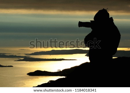 Silhouette of a photographer at sunset near Preikestolen, Norway