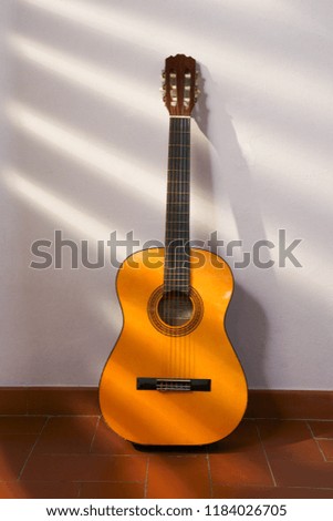 Spanish guitar on a wall with sun rays.