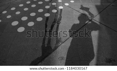 Man standing on sidewalk with black shadow, black and white