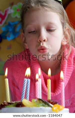 Young girl blowing  birthday candles
