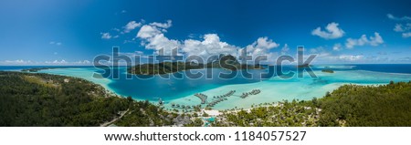 Panoramic aerial view of luxury overwater villas with palm trees, blue lagoon, white sandy beach and Otemanu mountain at Bora Bora island, Tahiti, French Polynesia (Bora Bora Aerial) Royalty-Free Stock Photo #1184057527