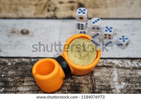 Random cost of bitcoin concept, bitcoin and dices on wooden table. Business ideas concept and gambling risk currency. Copy space for text. Selective focus.