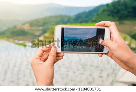 Girl capturing rice terrace scenery with a smart phone