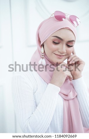 Fashion portraiture of young beautiful muslim woman wearing hijab. Image contain certain grain or noise and soft focus.