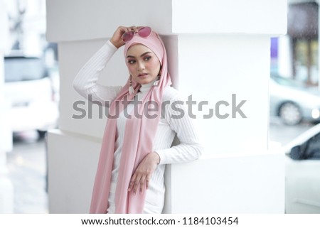 Fashion portraiture of young beautiful muslim woman wearing hijab. Image contain certain grain or noise and soft focus.