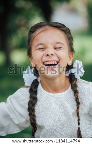 Portrait of happy little girl with two braids ready to go to first day of school
