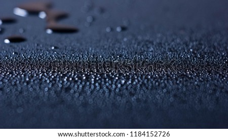 The water drops fell on the smooth blue paper
