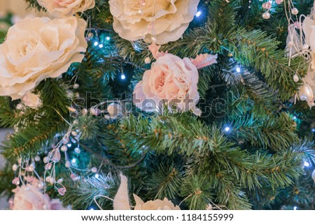 close up of christmas tree decorated with tender pink flower.