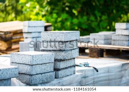 Stack of concrete paving slabs tiles ready for laying pavement. Installing new tiles or slabs at driveway, sidewalk or patio at public or private residence.