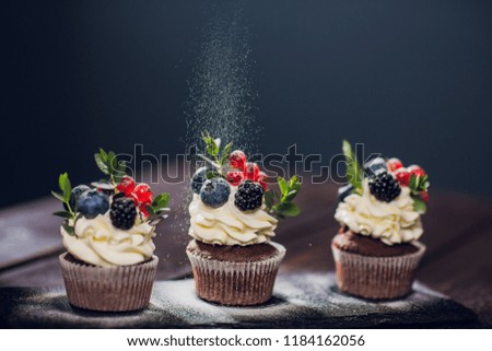 muffin decoration .No powdered sugar. woman confectioner throws powder