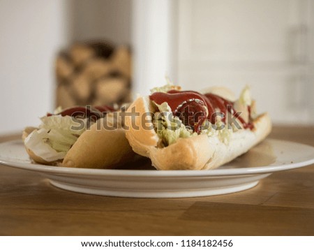 Hot dog with vegetables, ketchup and mustard on wooden table.