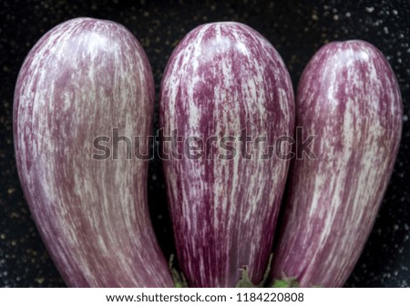 Three graffitti eggplants on black background