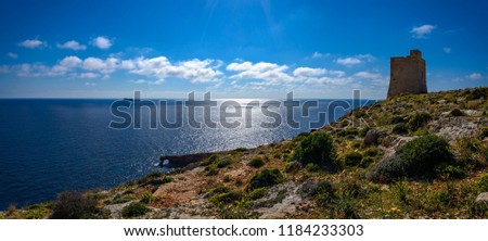 Maltese coastal landscape with a natural arch, Hamrija Tower and Filfla island - Panorama from 3 pictures