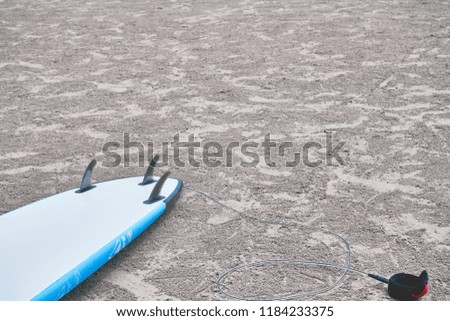 Surfboard on clear sand beach with copy space for content