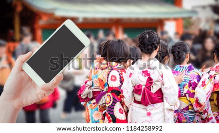 travel japan and technology concept from beauty hand hold smart phone support travel with  japanese girl group with kimono cloth take picture at fushimi inari japan