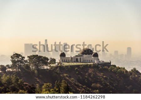 Griffith Observatory located in Los Angeles, California, USA at noon and LA downtown skyscrapers on the background.