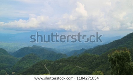 Beautiful landscape view of road on the mountains with clouds and rain in the countryside of Thailand. 

