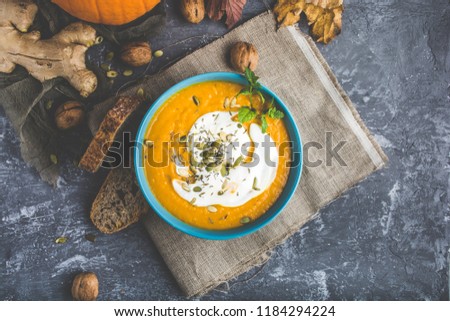 Pumpkin cream on a stylized gray table decorated with autumn symbols.