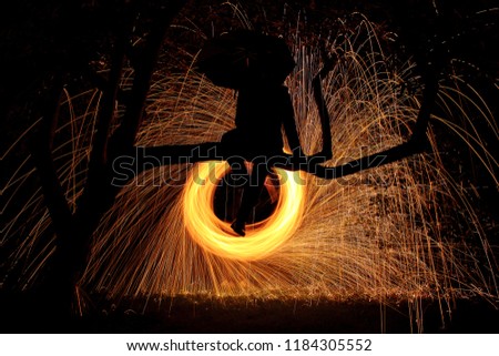 Silhouette of Man with an Umbrella in Front of Sparks