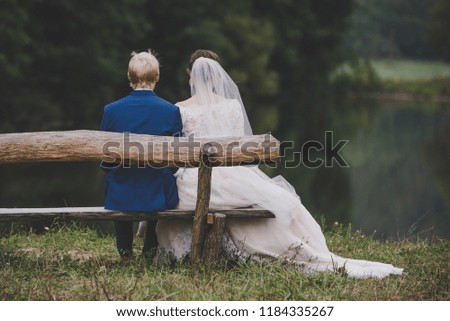 Wedding couple on wooden bench in nature by lake, romantic, valentine photo full of love