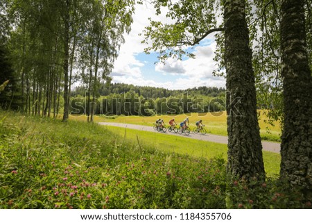 Cyclists riding through green hilly countryside