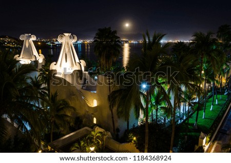 Horizontal photo in color about a resort on the beach at night