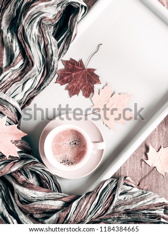Autumn composition. Cup of coffee, autumn dry leaves and roses, scarf on light pastel beige background. Autumn, fall, concept. Flat lay, top view, copy space

