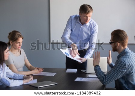 Stressed employee disagreeing with boss blaming for mistake in financial report, dissatisfied ceo team leader arguing with worker about bad work charging fault upon duties failure or demanding result Royalty-Free Stock Photo #1184389432