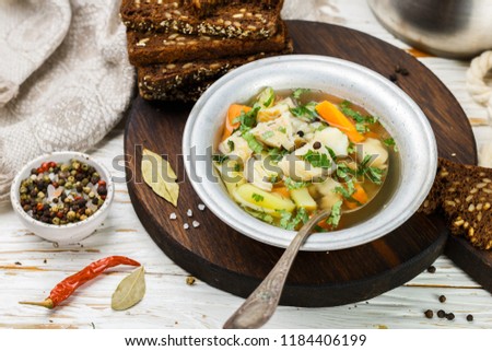 Fresh white fish soup with carrots, potatoes, onions, herbs and spices. Rustic style. Selective focus