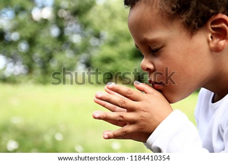 little boy praying in the garden with hands together reel people with green background stock image and stock photo