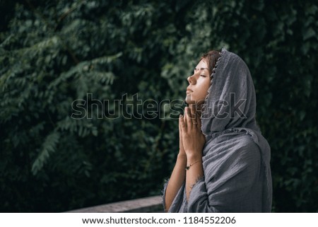 The girl prays folded palms facing the sky
