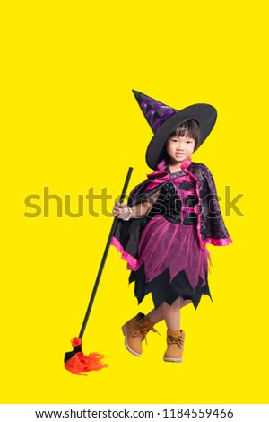 Kid of Witch Halloween Concept. Portrait of a happy funny asian girl (5 years old) in witch costume showing gestures and acting to the camera with isolated over yellow background and clipping path.