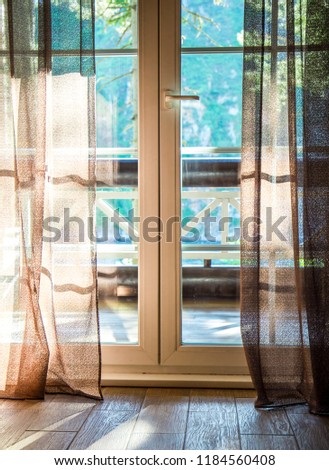 French doors open onto a balcony with a view of leafy green trees. nature. relax concept. vocations