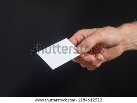 simple business card mockup on black background. Hand holding card.