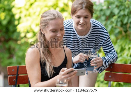 Two female friends looking at pictures or text on a phone