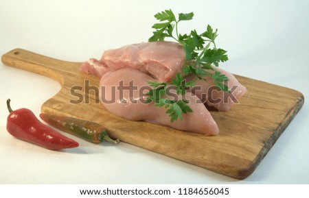 Chicken white meat, fillets, chopped parsley and red hot pepper. A picture on a white background close-up.

