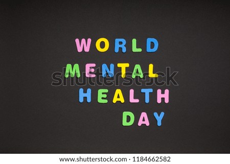 Creative colorful text made from plastic letters World Mental Health Day writing on black paper background with copy space. Holiday message concept, celebration card template
