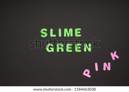 Creative colorful text made from plastic letters Slime green writing on black paper background with copy space. Trendy Color concept blogger template
