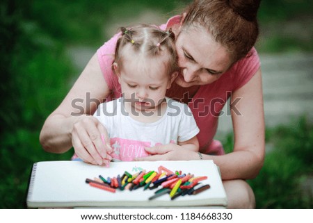grandmother teaches her granddaughter how to draw