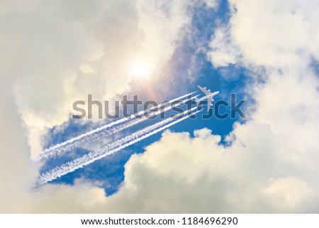 Airplane flies high in the sky, a journey through the clouds and a sunny glare Royalty-Free Stock Photo #1184696290