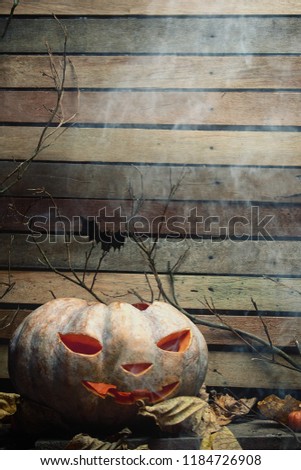 Halloween pumpkin with scary face with spooky wooden background 