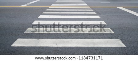 crosswalk on the road for safety when people walking cross the street, Pedestrian crossing on a repaired asphalt road, Crosswalk on the street for safety.