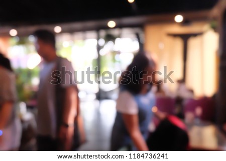 Blurred people are sitting on table in cafe or restaurant.