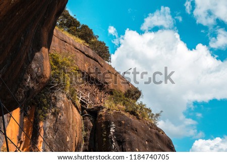 low angle view phutok rock mountain with wood bridge on moutain and clouds blue sky.