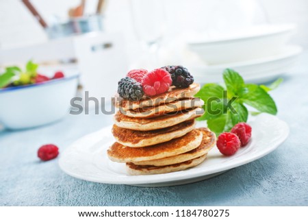 pancakes with fresh berries on plate, stock photo