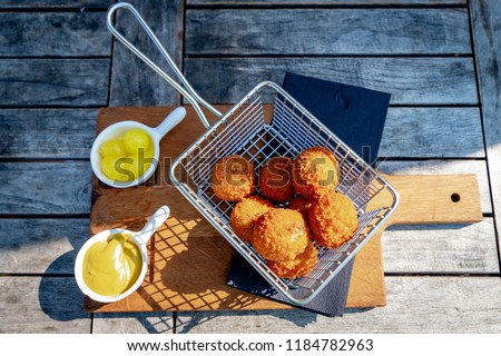 A Dutch meat-based snack (Bitterballen) served with mustard and pickled garlic, Typically containing a mixture of beef or veal, Bitterballen are one of Holland's favorite snacks. Royalty-Free Stock Photo #1184782963