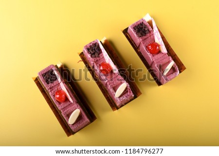 Rhubarb and cherry chocolate mousse with cherry on top view from above isolated on yellow background