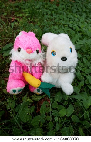 Soft toys: colorful hares on the grass in the garden
